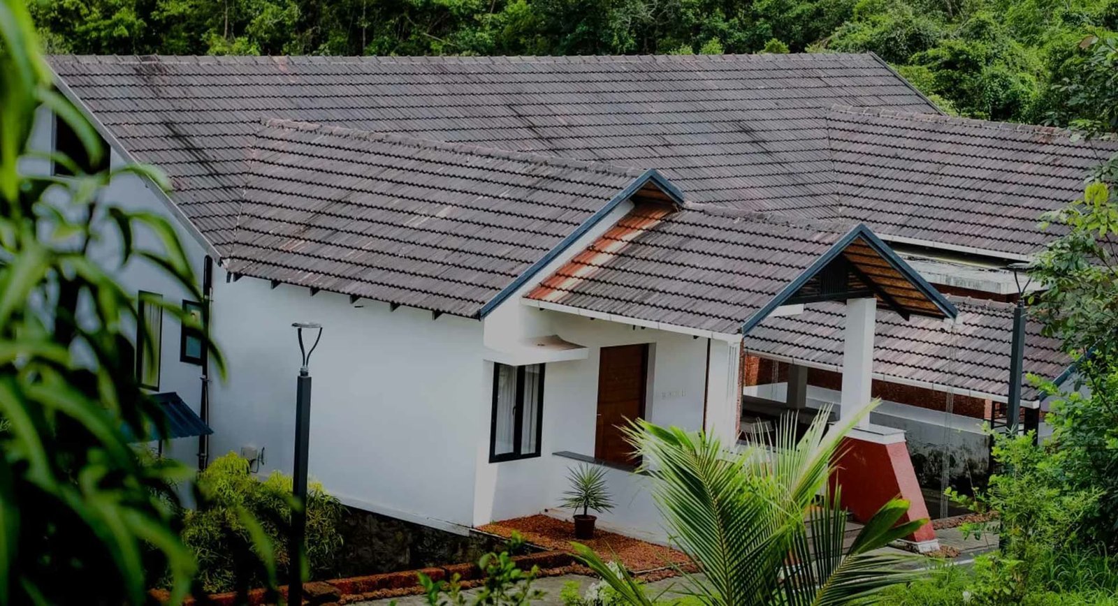 A white cottage at Vaidekam surrounded by dense greenery