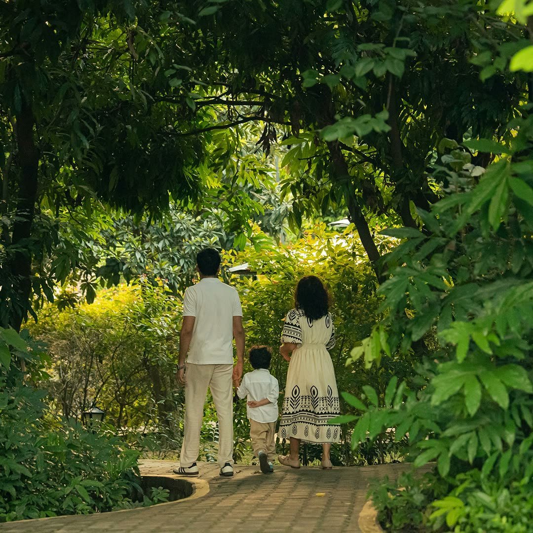 A family walking together along a shaded path at Vaidekam