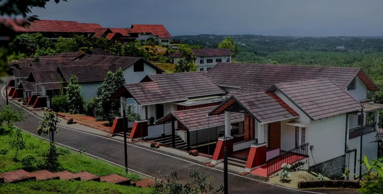 Aerial view of the white-roofed Vaidekam resort set among green grounds