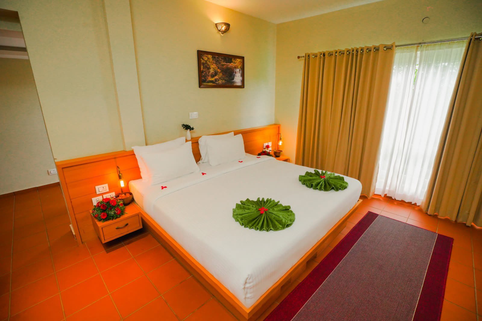 A guest room at Vaidekam with warm timber floors and a large bed